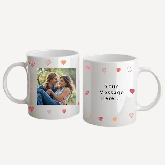 Personalised white mug with custom photo upload and personal message in a choice of fonts. Features a white background filled with love hearts. White handle and interior.