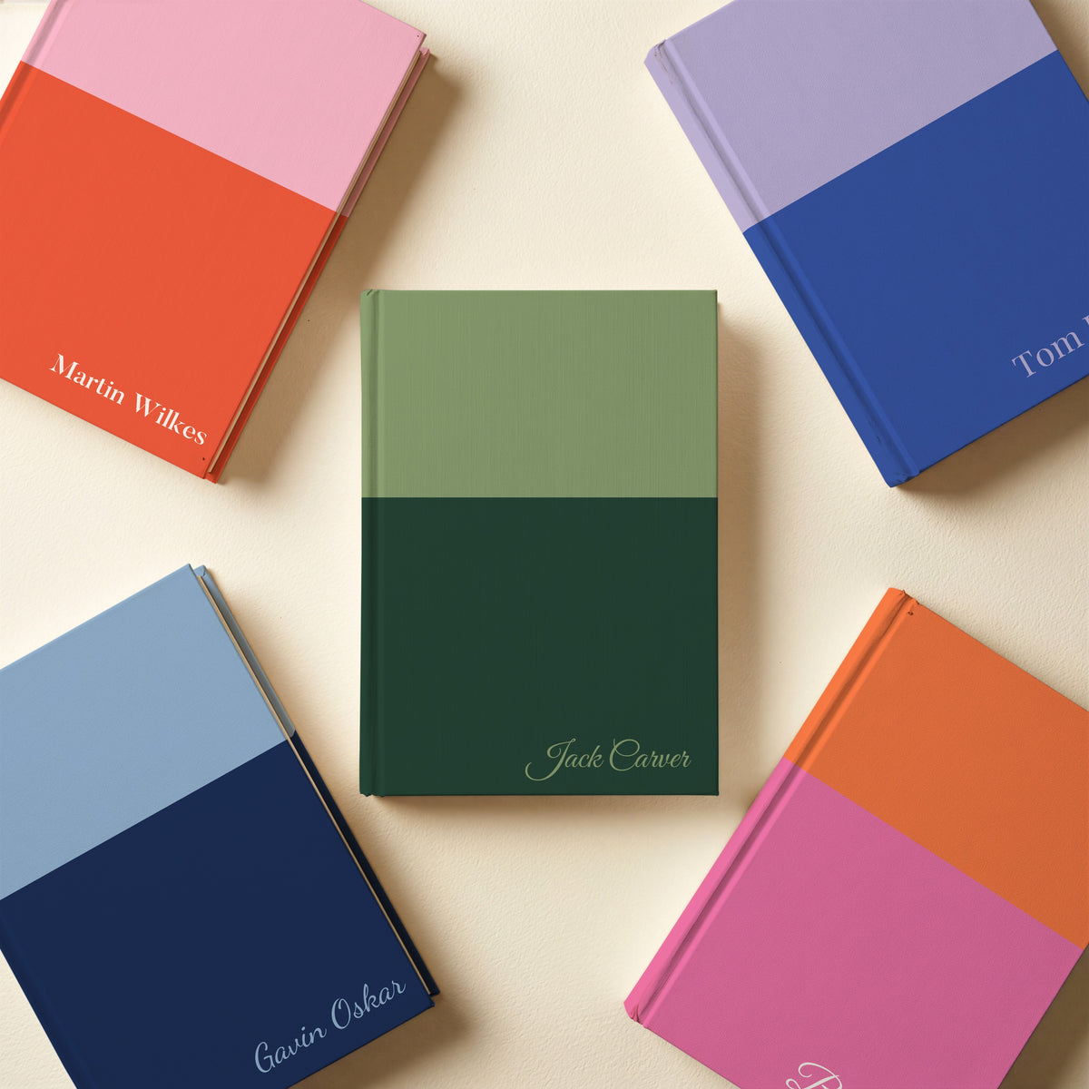 Five two tone name notebooks in sage and pine, pink and red, lilac and cobalt, sky and navy, and orange and pink, with names in different fonts