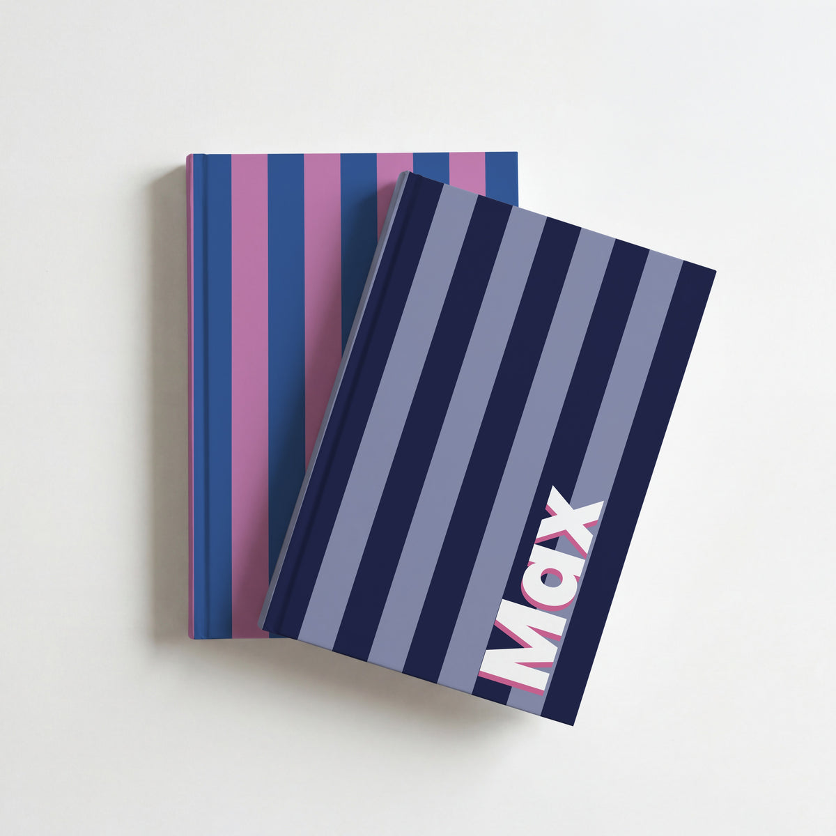 Two striped name notebooks, navy and periwinkle with Max on top of cobalt and orchid