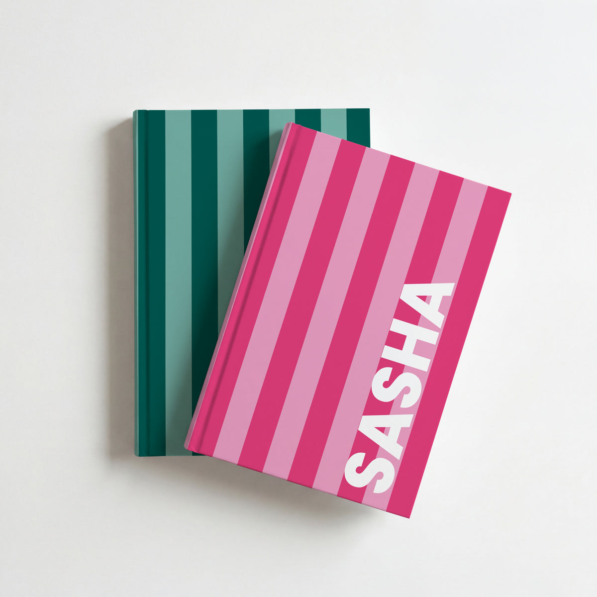 Two striped name notebooks, hot pink with SASHA on top of bottle green