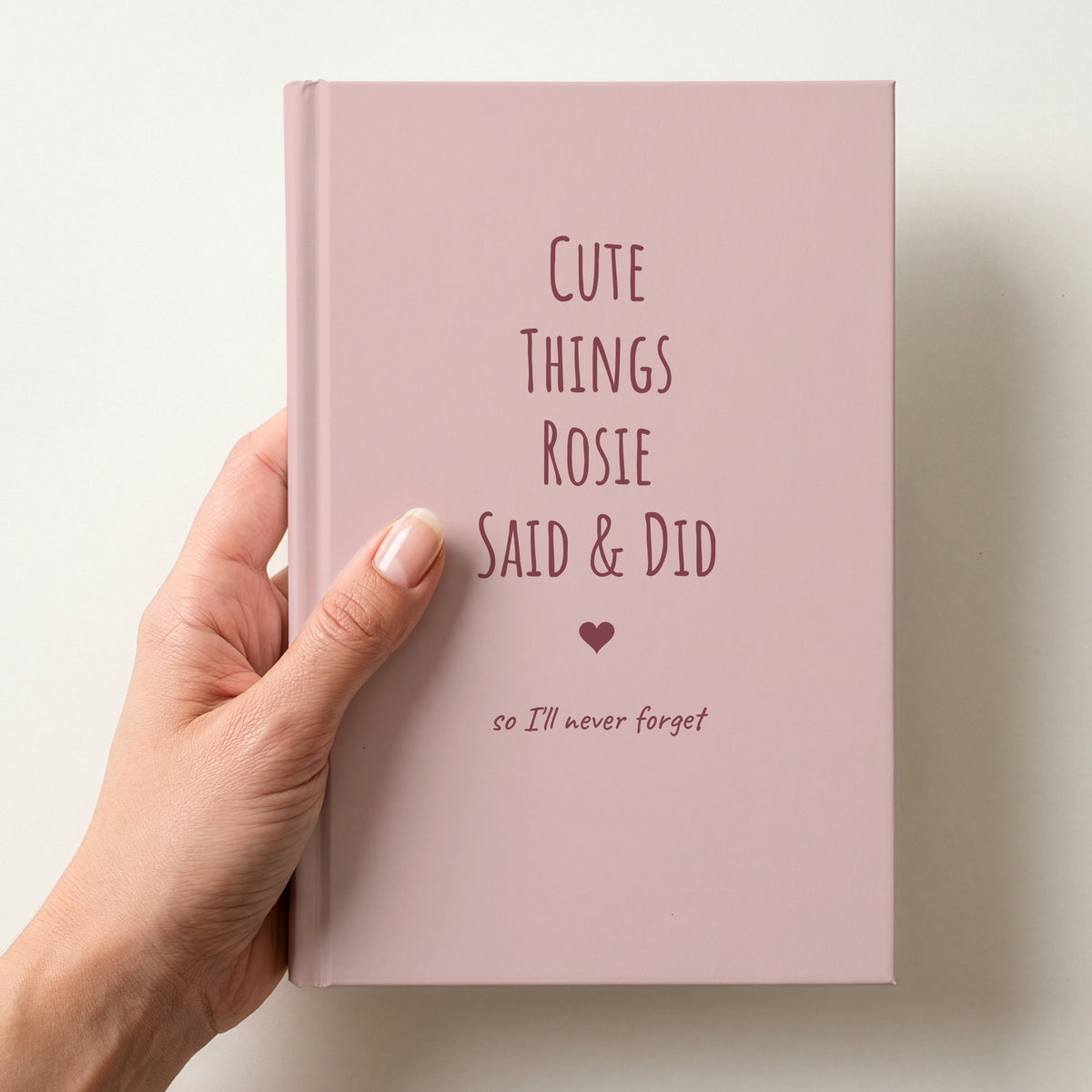 Hand holding a blush pink personalised journal with rose lettering reading Cute Things Rosie Said & Did