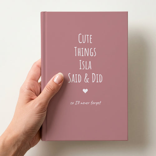 Hand holding a dusty rose personalised journal reading Cute Things Isla Said & Did