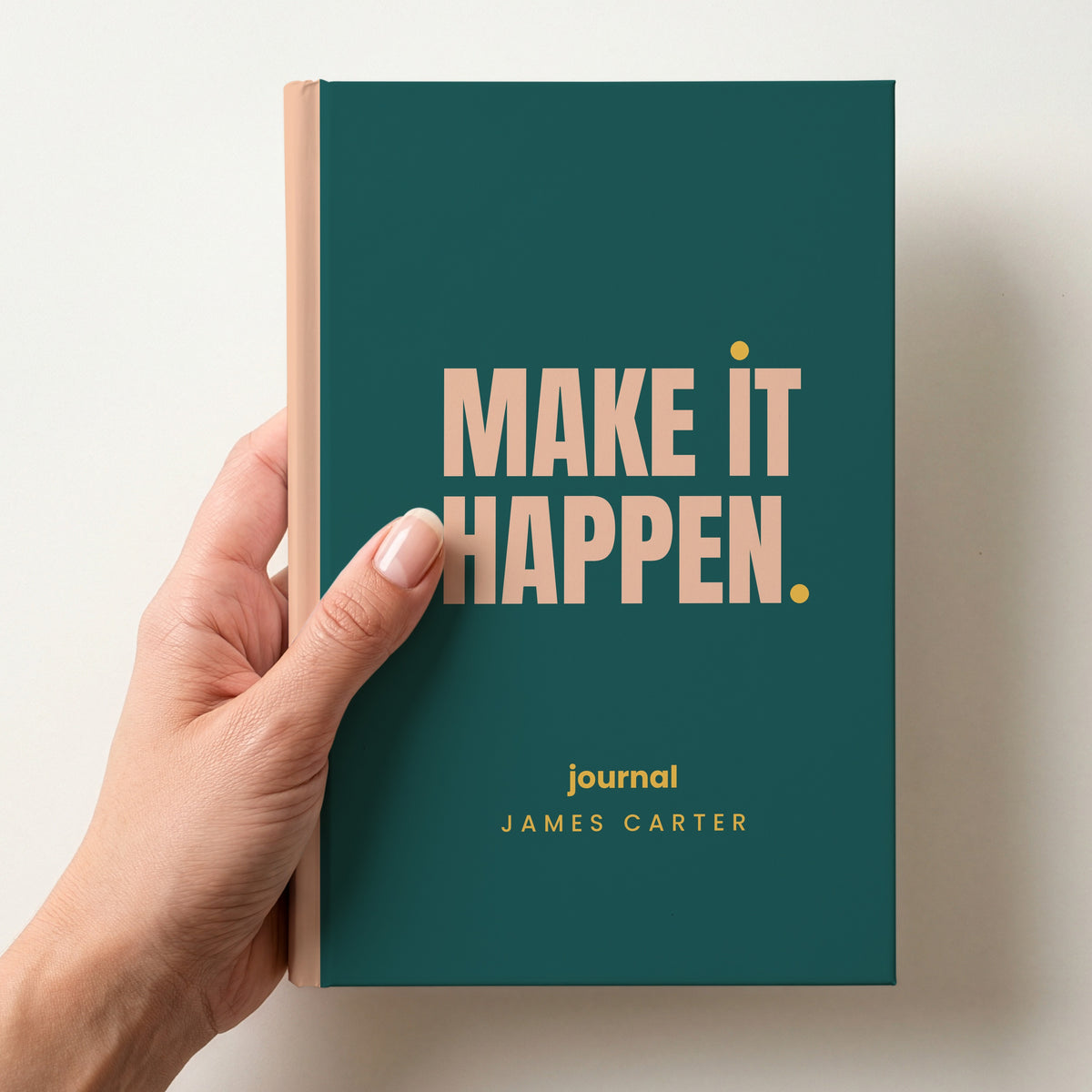 Hand holding a teal personalised notebook with 'MAKE IT HAPPEN.' in peach and 'journal' and the name James Carter below