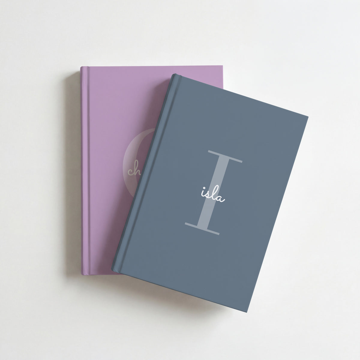 Two personalised initial journals, slate for isla on top of lavender for charlotte