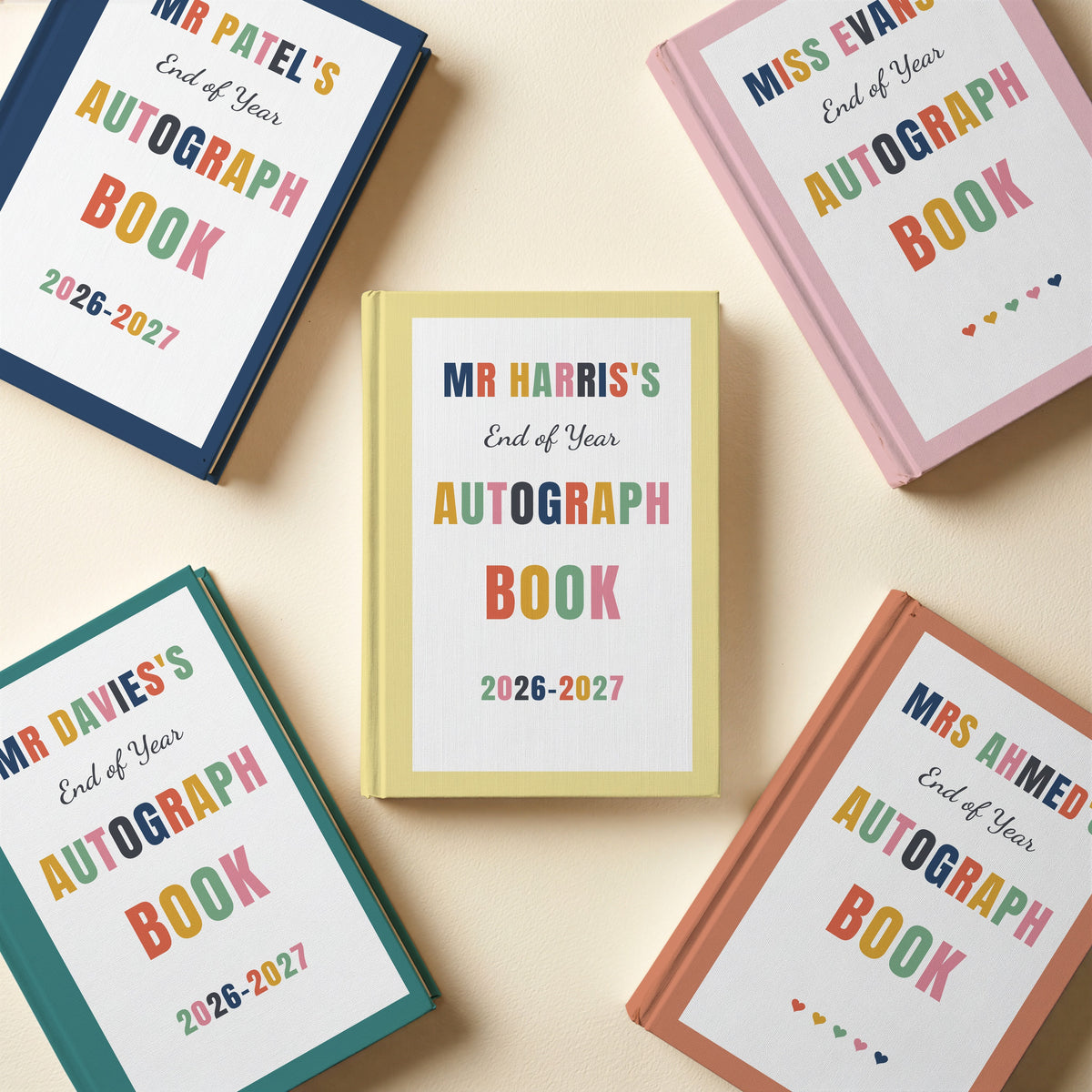 Five personalised teacher autograph books in blush pink, navy, teal, terracotta and butter yellow, some with a school year and some with hearts