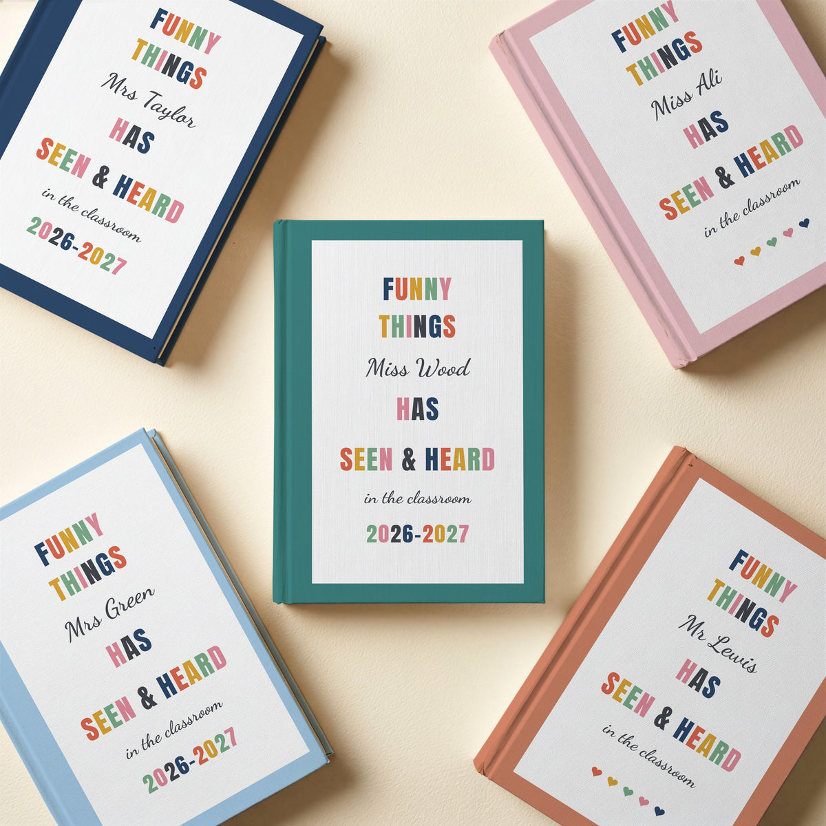 Five personalised Funny Things teacher journals in blush pink, navy, sky blue, terracotta and teal, some with a school year and some with hearts