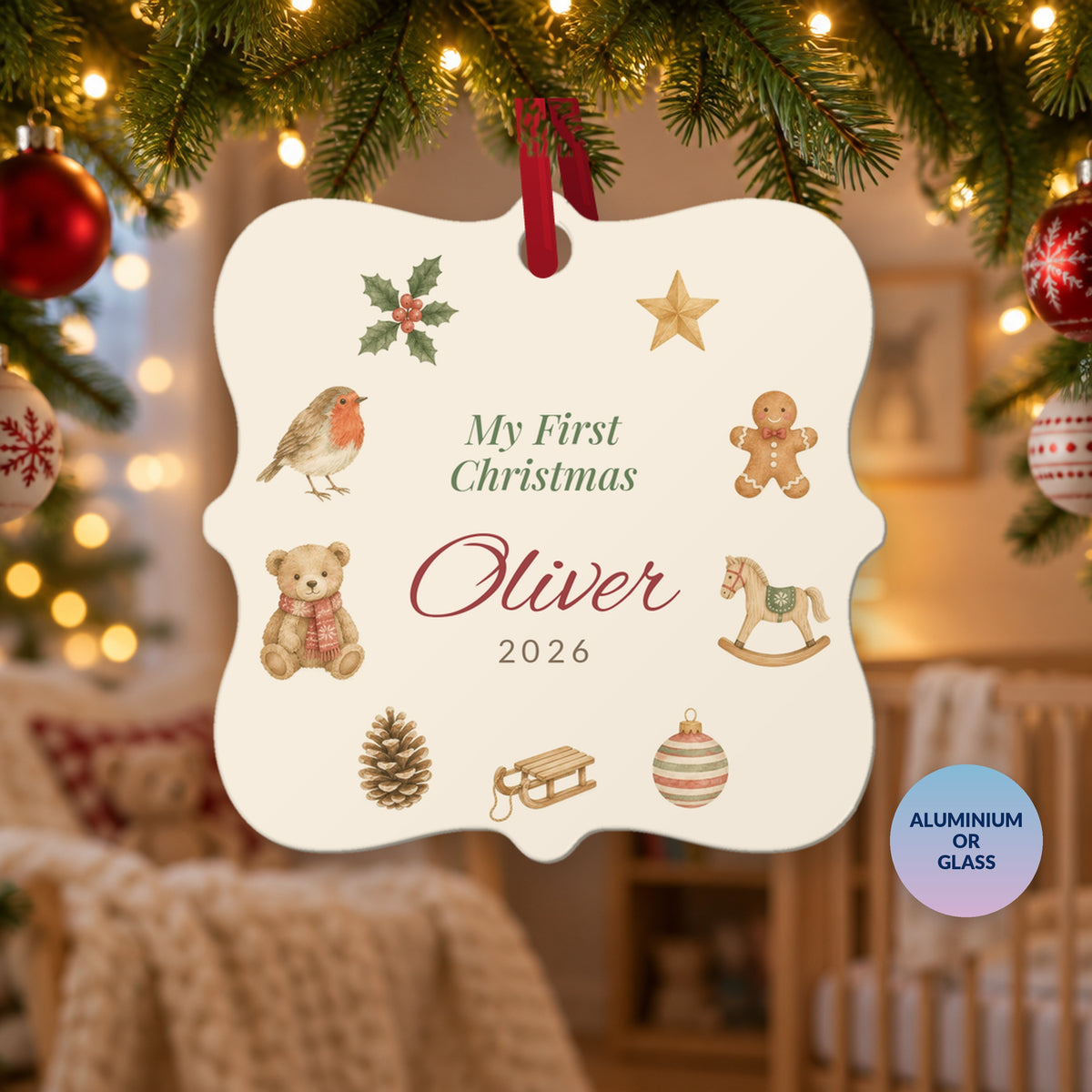 Personalised My First Christmas ornament for Oliver, 2026, with watercolour robin, teddy and rocking horse, hanging on a Christmas tree in a cosy nursery, with a badge reading Aluminium or Glass